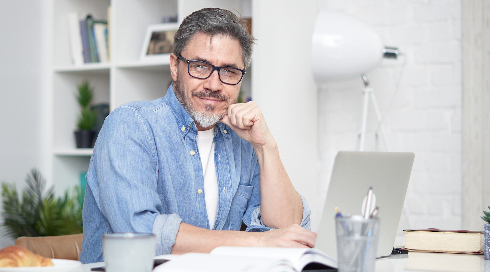 bigstock-Happy-older-man-working-online-408223760